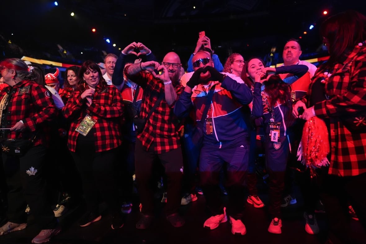 canada-invictus-games-20250216 Athletes in plaid jacket and tracks gesturing with a heart sign.