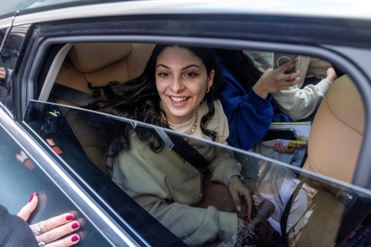 israel-palestinians-gaza-hostage-return A woman is smiling from a car.