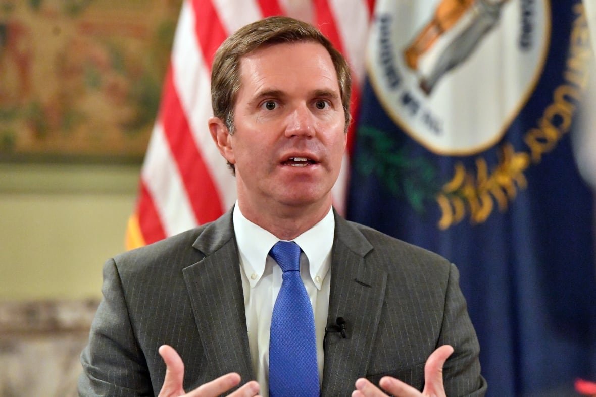kentucky-governor-1 Andy Beshear speaks while wearing a grey suit and blue tie
