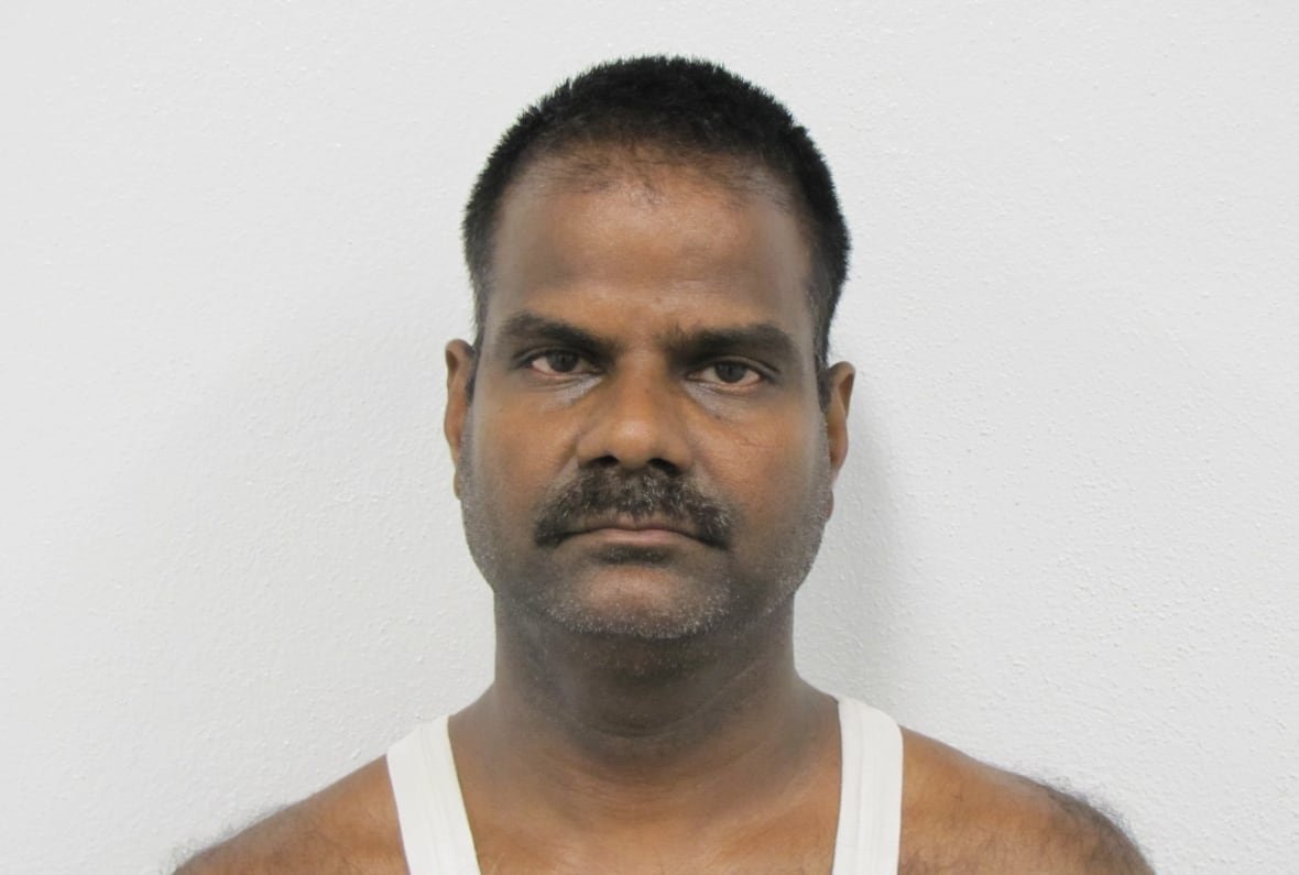thesingarasan-rasiah Mugshot photo of a man with a mustache and wearing a tanktop.