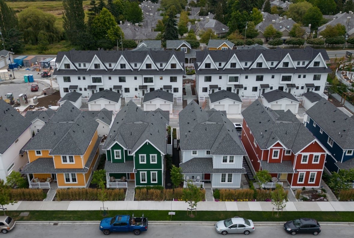 A row of houses with colorful fronts is shown from an aerial view.