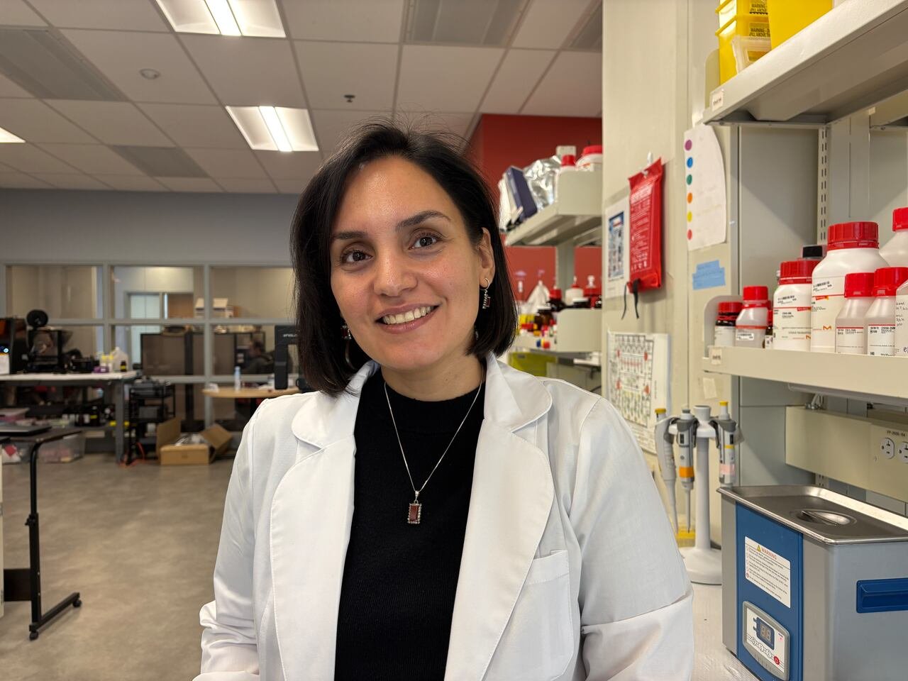 default-188 A woman in a lab coat smiles at the camera