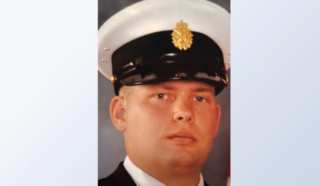 A man in a formal navy uniform