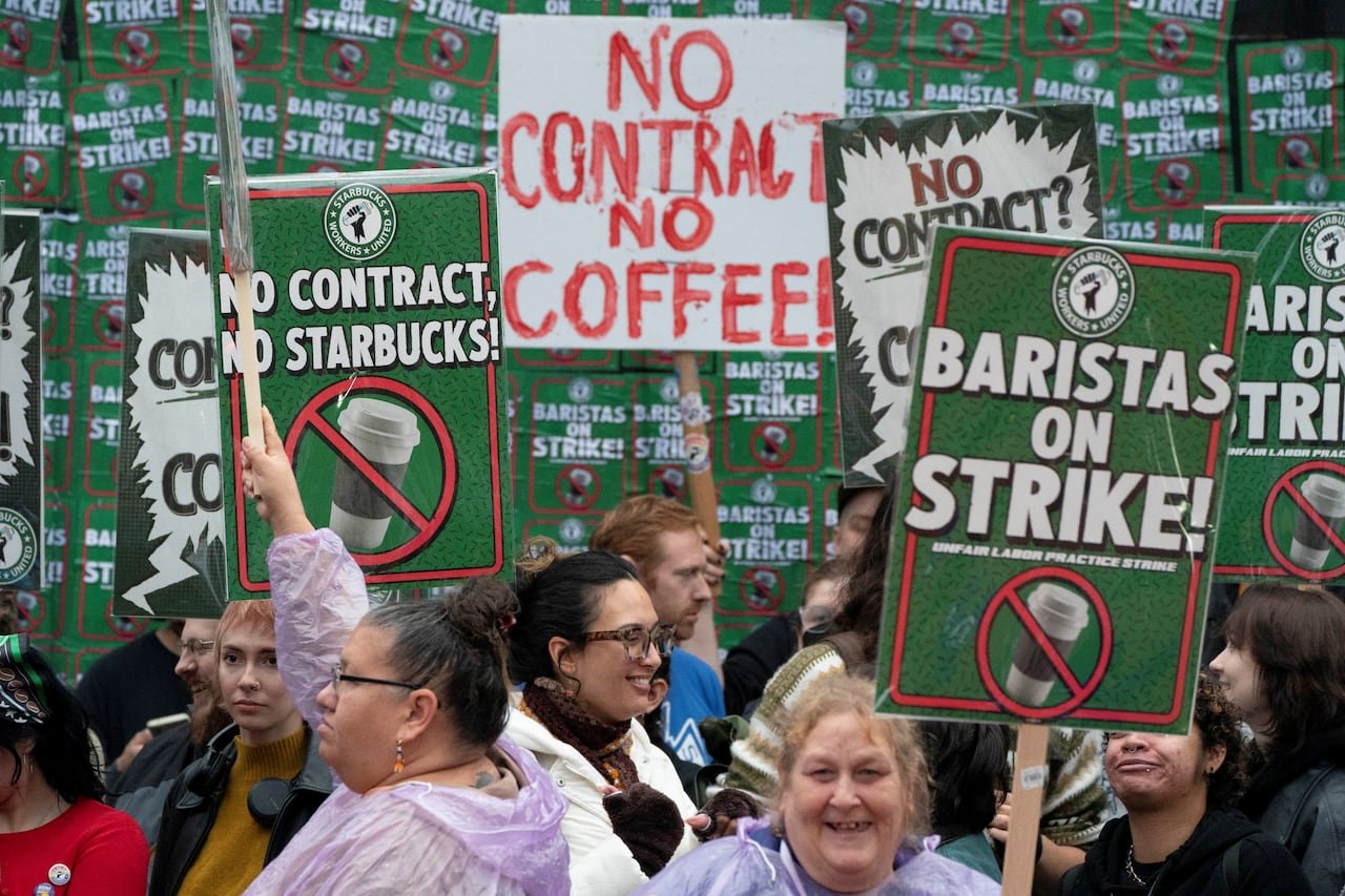 default-200 People hold up picket signs.